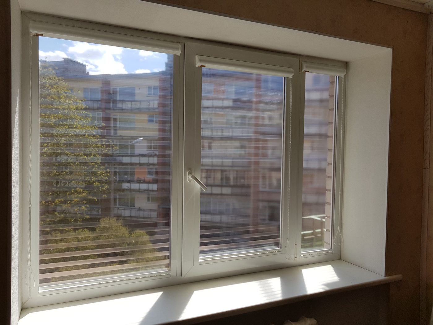 Screen kasešu žalūzijas dzīvokļa trīsvērtņu logā