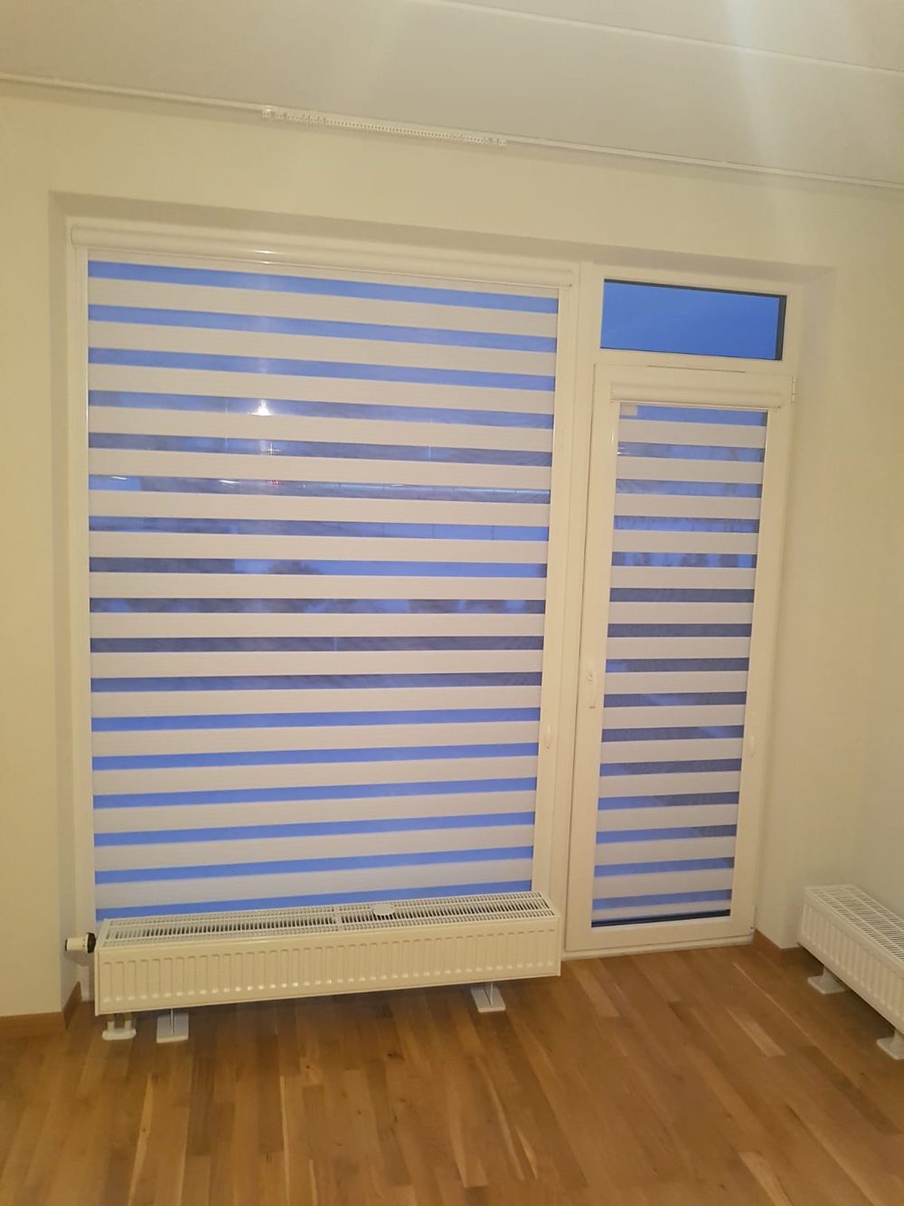 Hellblaue Kassetten-Doppelrollos Tag-Nacht an Fenster und Balkontür