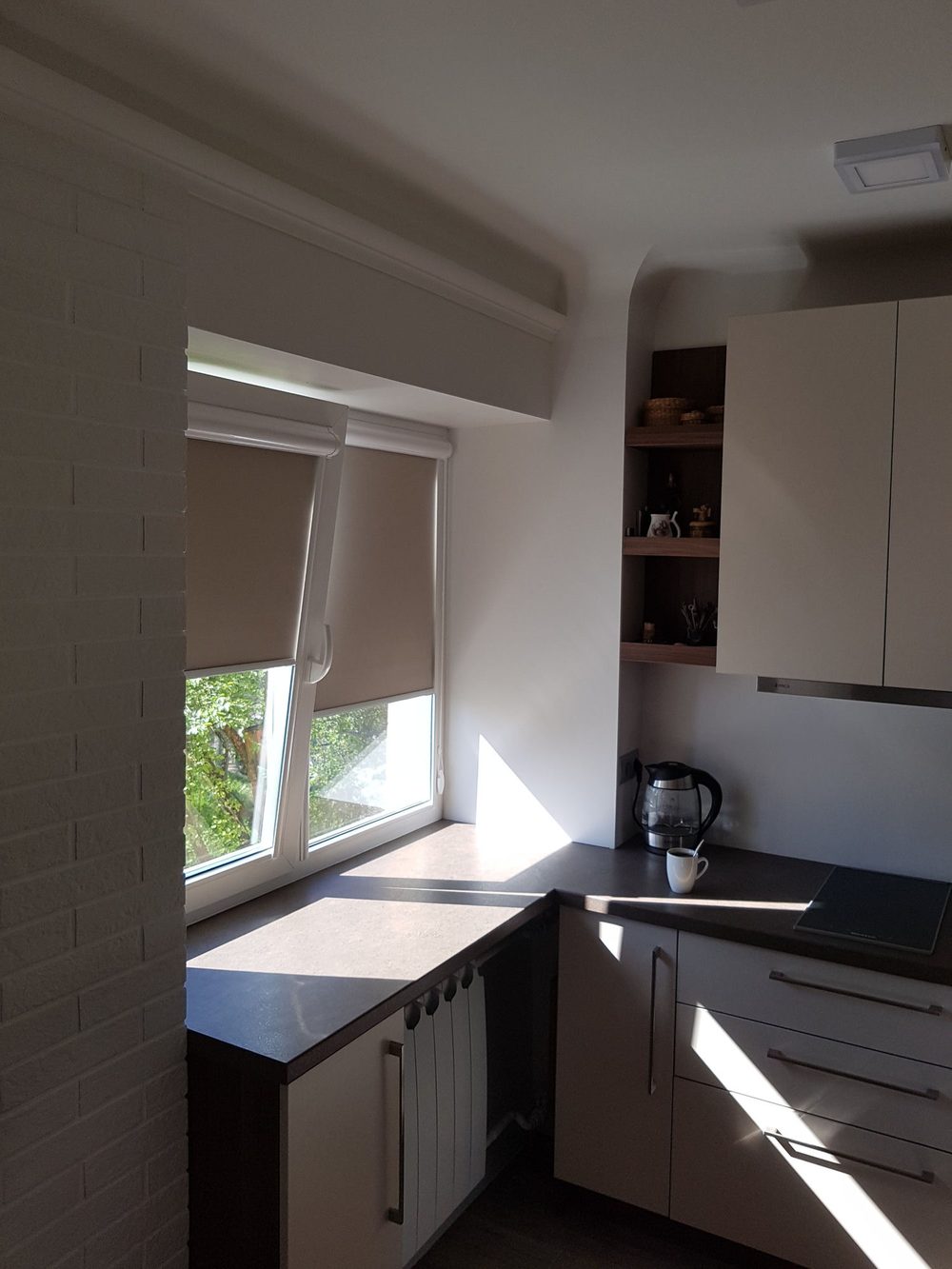 Bēšas Uni kasešu žalūzijas virtuves logā