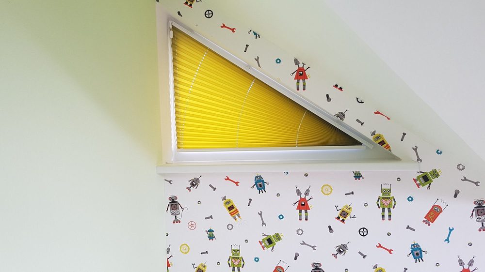 Gelbes Cosiflor Plissee am dreieckigen Fenster des Kinderzimmers